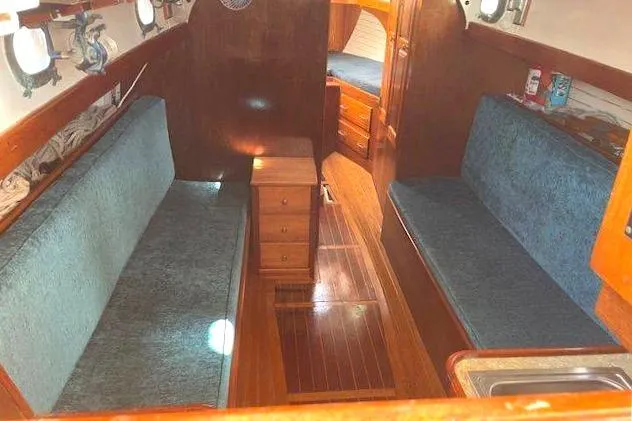 Slide: The Image of Interior of 1939 Alden Graves Coastwise Cutter 36, featuring wooden finishes and blue seating. - 2
