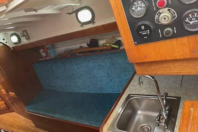 Slide: The Image of Interior of 1939 Alden Graves Coastwise Cutter 36, featuring a blue cushioned bench and compact sink. - 6