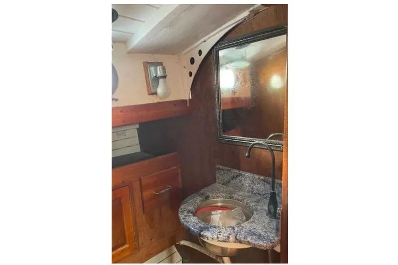 Slide: The Image of Interior of 1939 Alden Cutter yacht featuring a vintage sink and wooden cabinetry. - 9
