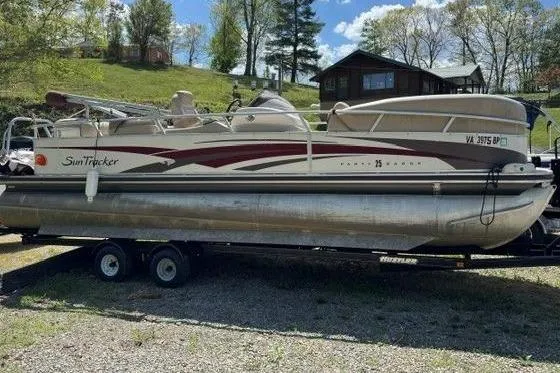 The Image of 2008 Sun Tracker Party Barge 25 Regency on trailer, parked outdoors. - 1