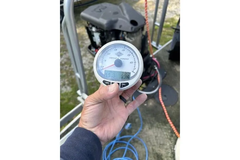 Slide: The Image of Hand holding a tachometer on a 2008 Sun Tracker Party Barge 25 Regency Edition. - 14