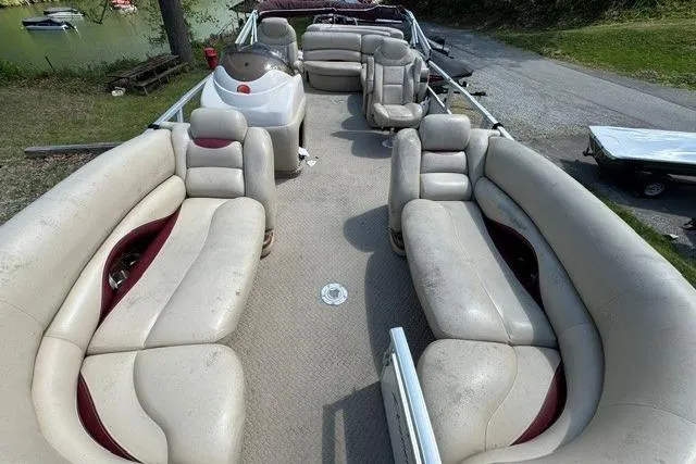 Slide: The Image of 2008 Sun Tracker Party Barge 25 Regency Edition with spacious seating and helm, docked near a lake. - 5