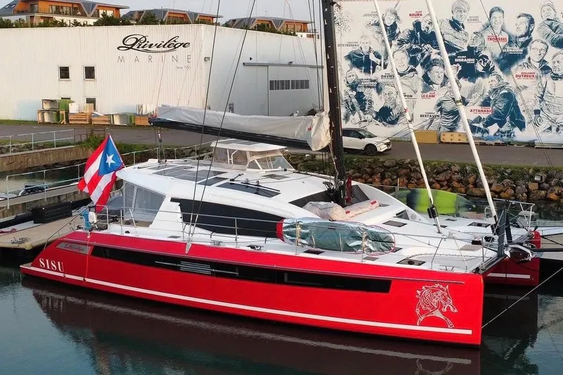 The Image of Red Privilege 510 catamaran docked at marina, 2022 model, with flag and mural backdrop. - 0