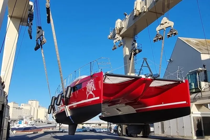 Slide: The Image of Red Privilege 510 catamaran being lifted by crane, 2022 model. - 1