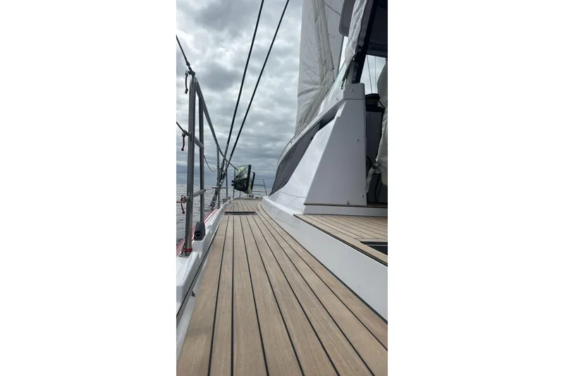 Slide: The Image of 2022 Privilege 510 yacht deck with sleek design and wooden finish under cloudy skies. - 3