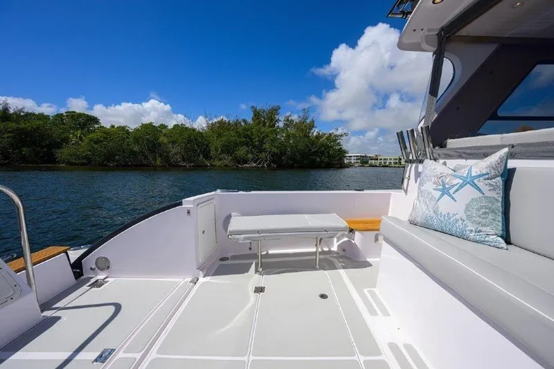 Slide: The Image of 2022 True North 34 boat deck with seating, table, and scenic water view. - 14