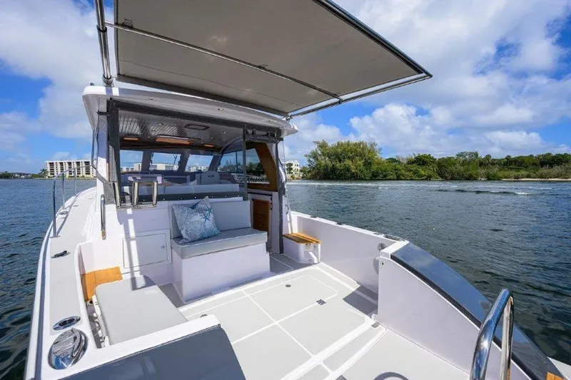 Slide: The Image of 2022 True North 34 boat with spacious deck and seating, cruising on a sunny day. - 24