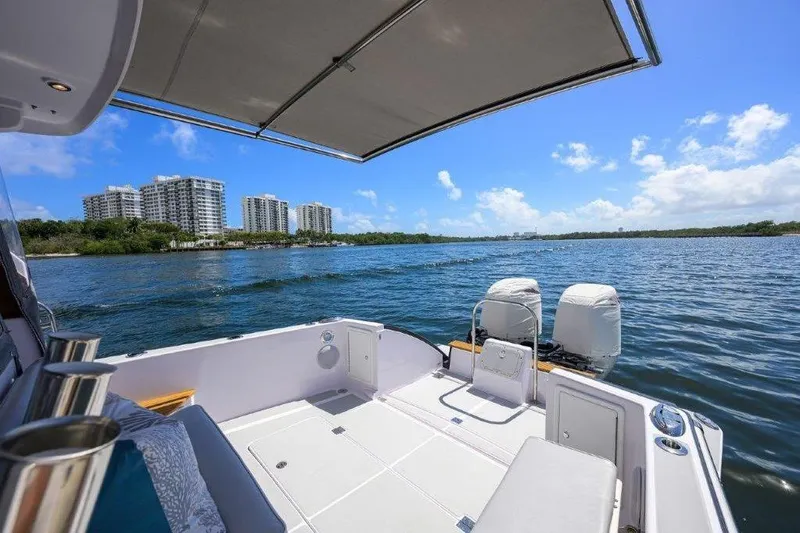 Slide: The Image of True North 34 boat deck overlooking scenic waterfront with modern buildings, 2022 model. - 25