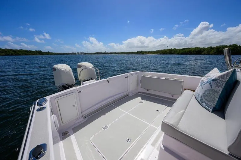 Slide: The Image of 2022 True North 34 boat deck with seating, overlooking serene water and blue sky. - 30