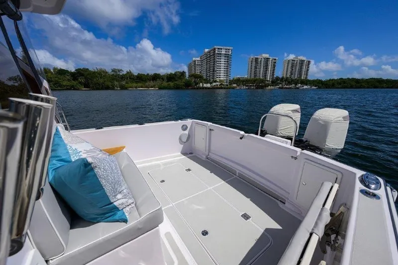 Slide: The Image of True North 34 boat interior with cushions, overlooking water and city skyline, 2022 model. - 32