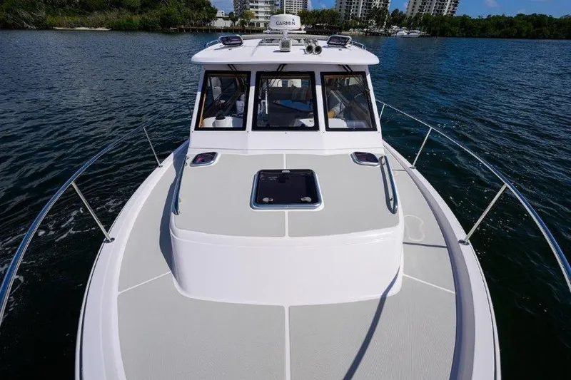 Slide: The Image of 2022 True North 34 boat cruising on a serene waterway with lush greenery. - 40