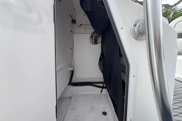 Slide: The Image of 2021 Sportsman Tournament 234 SBX Bay Boat interior storage compartment with wiring visible. - 13