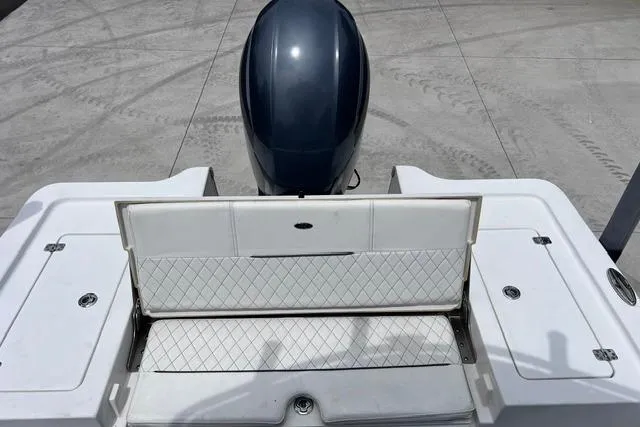 Slide: The Image of 2021 Sportsman Tournament 234 SBX Bay Boat with open storage compartment and outboard motor. - 7