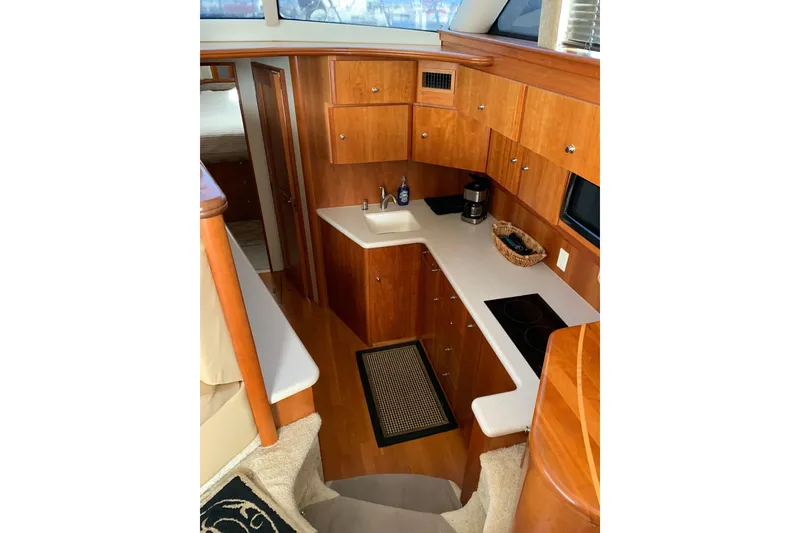 Slide: The Image of Interior of 2002 Silverton 42 Convertible yacht with wooden cabinetry and modern kitchen amenities. - 11