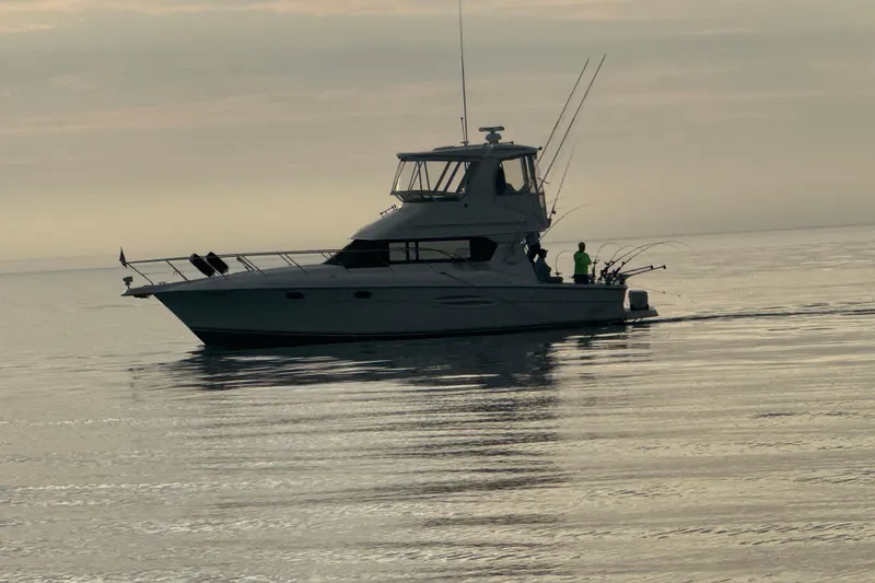 Slide: The Image of 2002 Silverton 42 Convertible yacht on calm waters at sunset. - 12