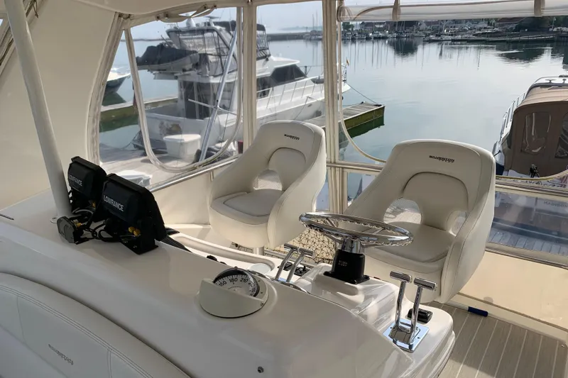 Slide: The Image of Interior helm of 2002 Silverton 42 Convertible yacht with dual seats and navigation equipment. - 5