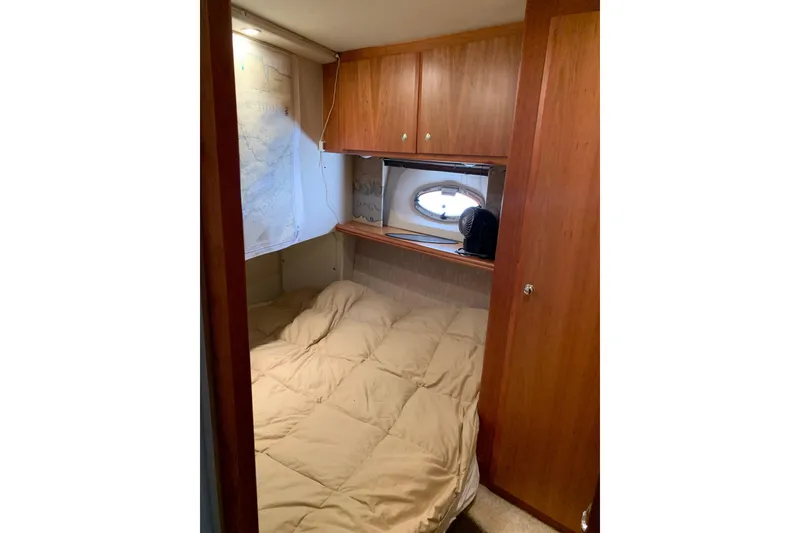 Slide: The Image of Cozy cabin interior of 2002 Silverton 42 Convertible yacht with wood cabinetry and porthole. - 8
