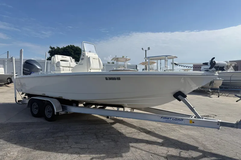 The Image of 2021 Pathfinder 2500 Hybrid boat on trailer, parked outdoors under clear sky. - 1