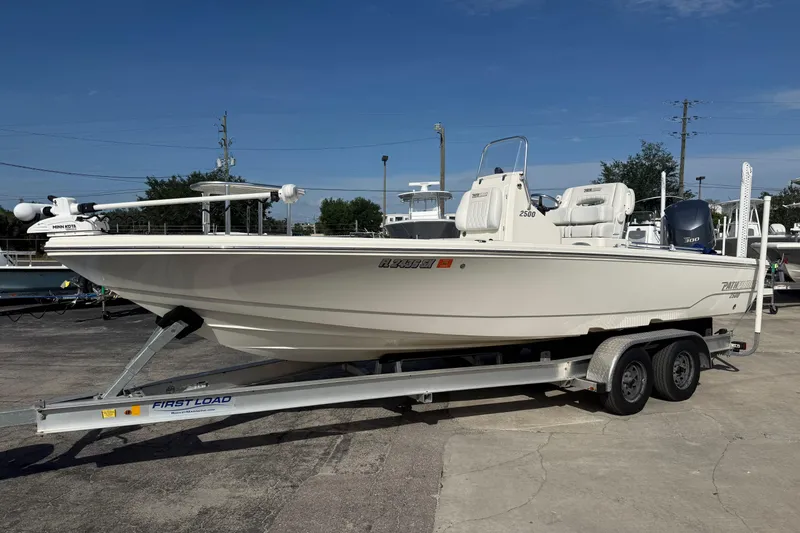 Slide: The Image of 2021 Pathfinder 2500 Hybrid boat on trailer, parked outdoors under clear blue sky. - 23