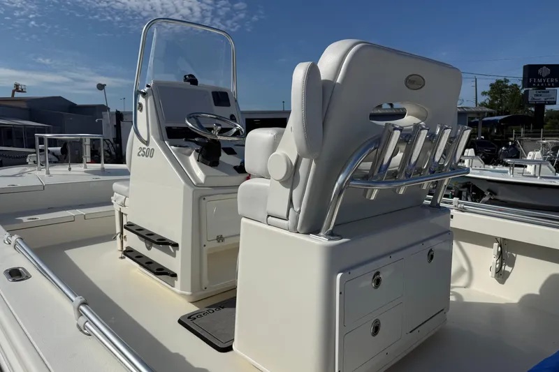 Slide: The Image of 2021 Pathfinder 2500 Hybrid boat interior with steering console and seating under clear blue sky. - 7