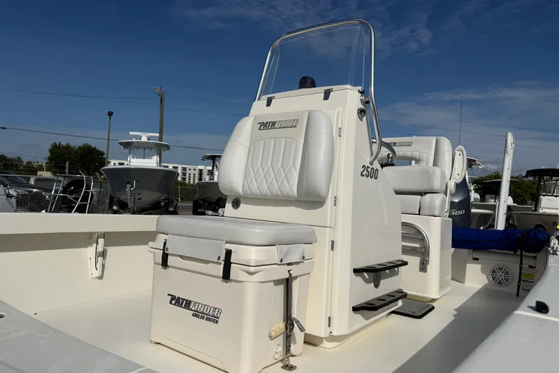 Slide: The Image of 2021 Pathfinder 2500 Hybrid boat interior with seating and storage under clear blue sky. - 9