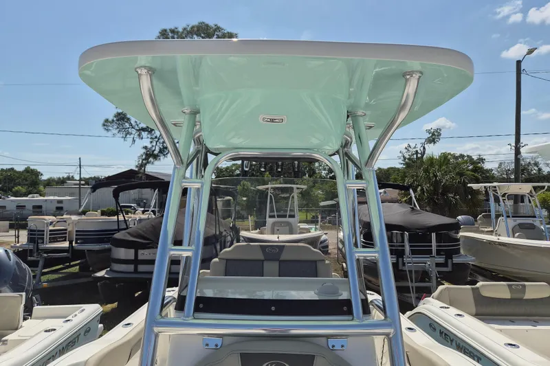 Slide: The Image of 2026 Key West 239 FS boat with T-top, parked in a marina under clear skies. - 18