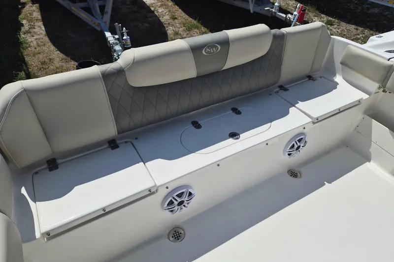 Slide: The Image of 2026 Key West 239 FS boat seating area with storage compartments and speakers. - 5