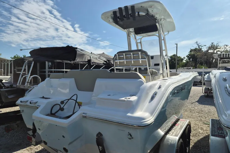 Slide: The Image of 2026 Key West 239 FS boat, rear view, parked on a trailer under a clear sky. - 21