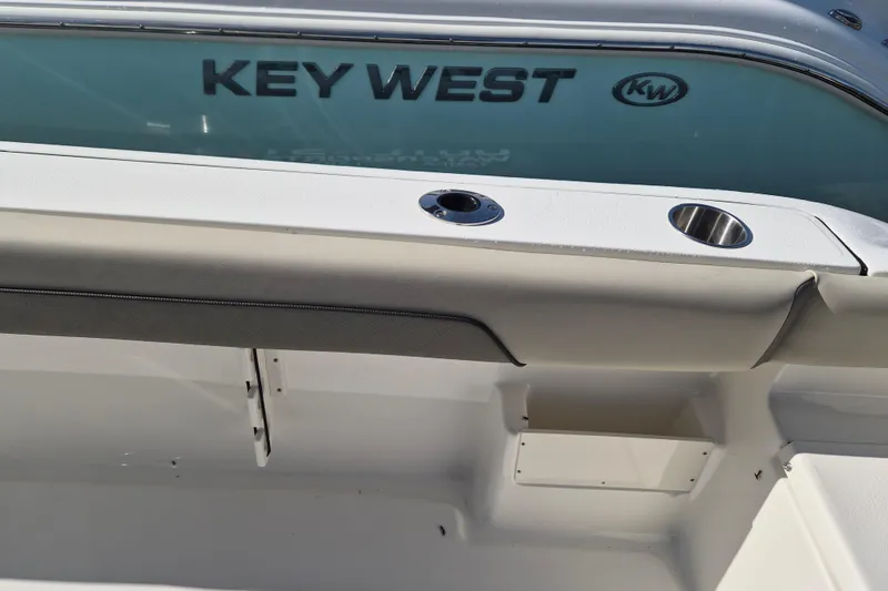 Slide: The Image of 2026 Key West 239 FS boat interior with cup holders and branding. - 4