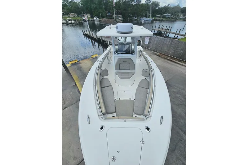 Slide: The Image of 2021 Sea Pro 259 Center Console boat docked by a serene waterfront. - 10