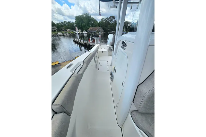 Slide: The Image of 2021 Sea Pro 259 Center Console boat docked by a serene waterfront. - 12