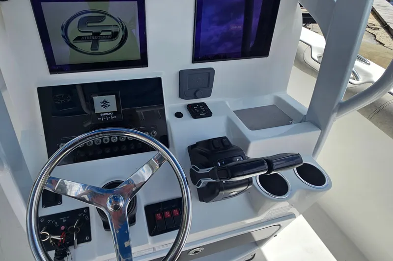Slide: The Image of 2021 Sea Pro 259 Center Console helm with steering wheel, controls, and dual cup holders. - 15