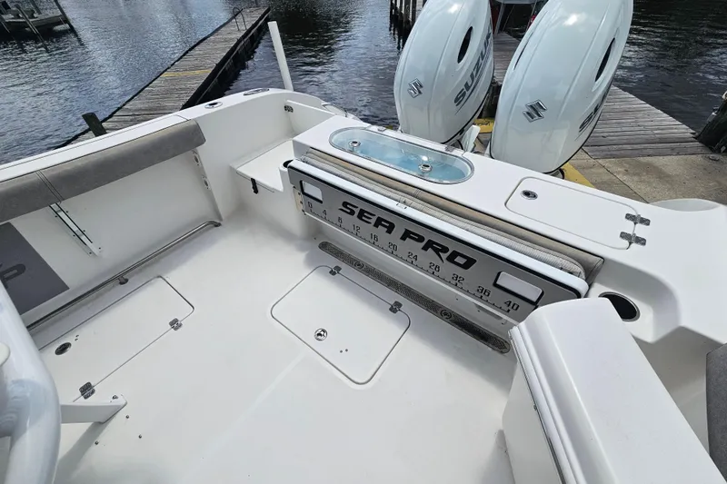 Slide: The Image of 2021 Sea Pro 259 Center Console boat interior with dual Suzuki engines at dock. - 19