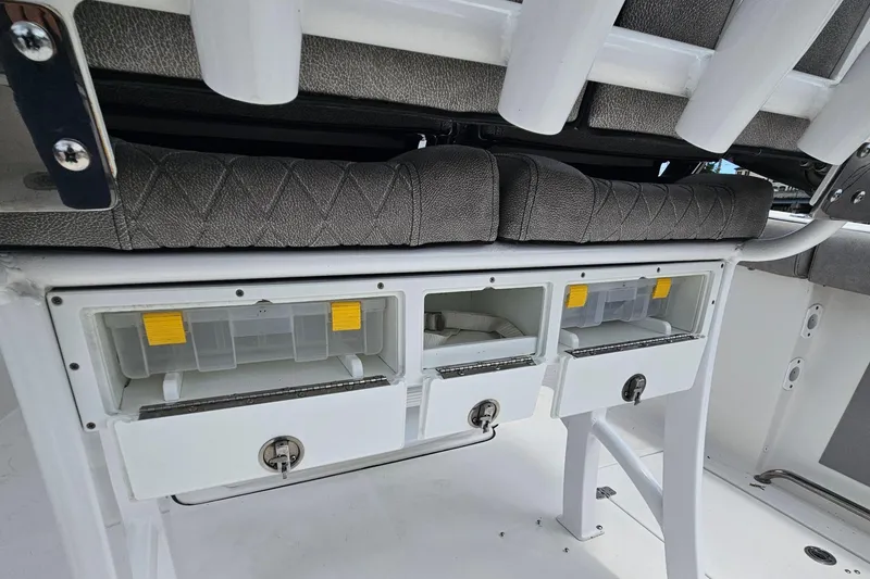 Slide: The Image of 2021 Sea Pro 259 Center Console storage compartments with cushioned seating and rod holders. - 20