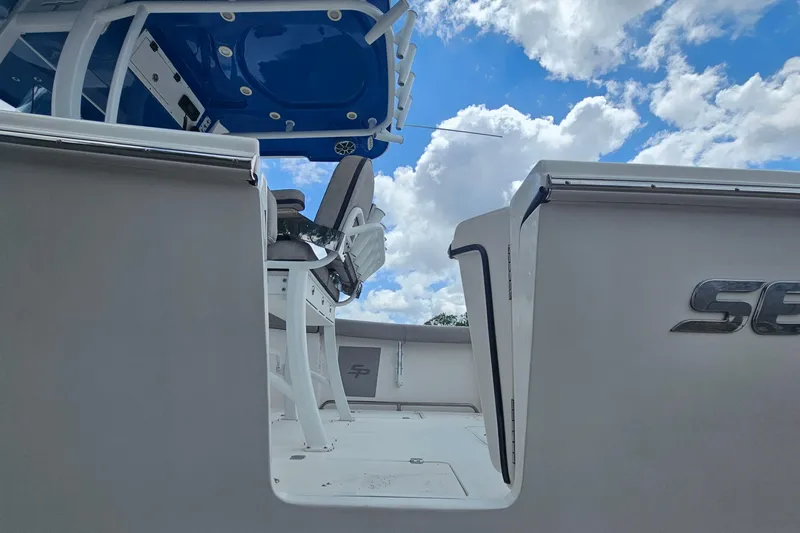 Slide: The Image of 2021 Sea Pro 259 Center Console boat interior with blue canopy and seating. - 6