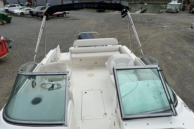 Slide: The Image of 2007 Robalo R227 Dual Console boat with open deck and seating, parked on gravel. - 14
