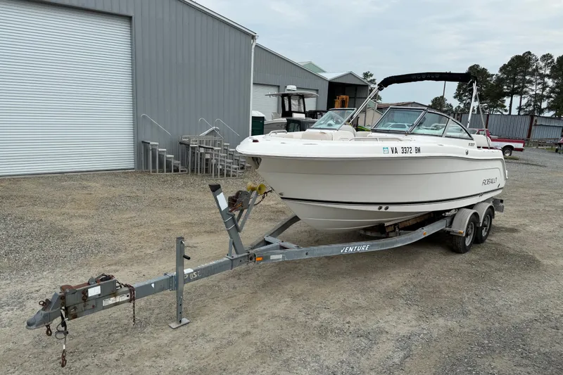 Slide: The Image of 2007 Robalo R227 Dual Console boat on trailer, parked near industrial buildings. - 20