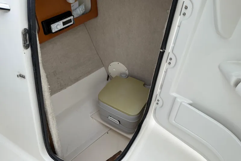Slide: The Image of 2007 Robalo R227 Dual Console boat interior with portable toilet and storage compartment. - 8