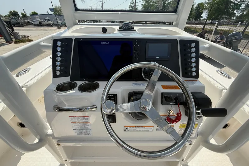 Slide: The Image of 2023 Robalo 246 Cayman boat dashboard with steering wheel and navigation controls. - 15