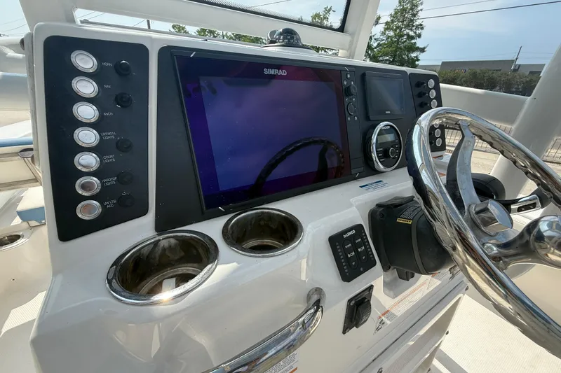 Slide: The Image of 2023 Robalo 246 Cayman boat dashboard with steering wheel and control panel. - 16