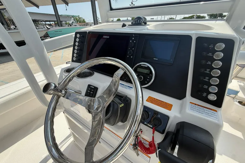 Slide: The Image of 2023 Robalo 246 Cayman boat dashboard with steering wheel and control panel. - 17