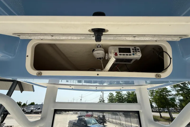 Slide: The Image of 2023 Robalo 246 Cayman boat console with radio equipment in storage compartment. - 18