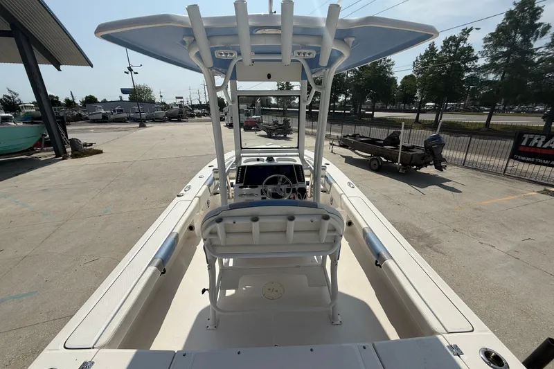 Slide: The Image of 2023 Robalo 246 Cayman boat with T-top, viewed from the rear in a marina setting. - 7