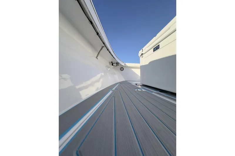 Slide: The Image of 2006 Albin 26 Center Console boat deck with Yeti cooler, under clear blue sky. - 14