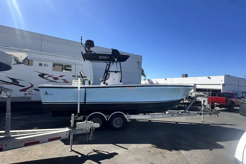 Slide: The Image of 2006 Albin 26 Center Console boat on trailer, parked outdoors under clear blue sky. - 18
