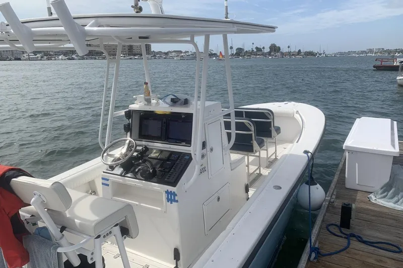 Slide: The Image of 2006 Albin 26 Center Console boat docked, featuring a modern helm and spacious seating. - 2