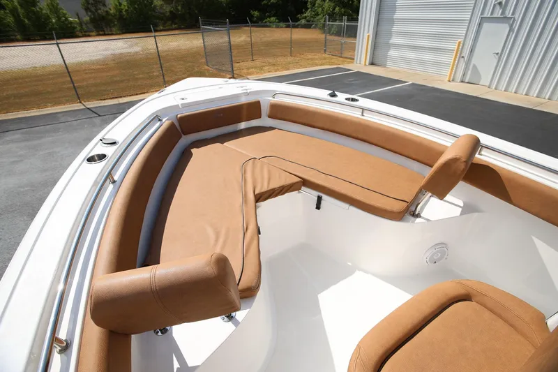 Slide: The Image of 2022 Sea Hunt Ultra 239 SE boat with tan cushioned seating in the bow area. - 18