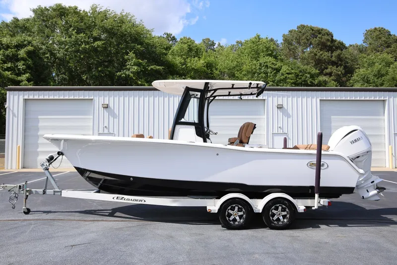 Slide: The Image of 2022 Sea Hunt Ultra 239 SE boat on trailer, parked outdoors near storage units. - 5