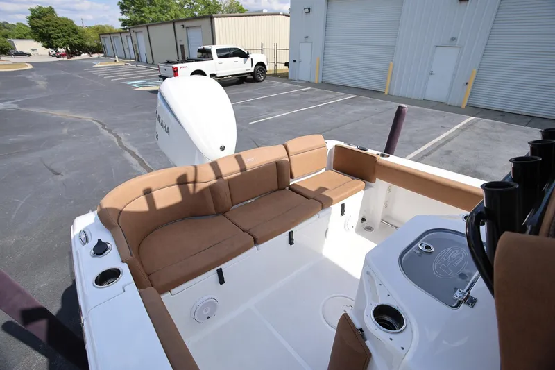 Slide: The Image of 2022 Sea Hunt Ultra 239 SE boat interior with tan seating and fishing rod holders. - 6