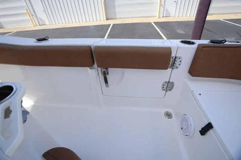 Slide: The Image of 2022 Sea Hunt Ultra 239 SE boat interior with brown cushioned seating and storage compartment. - 9